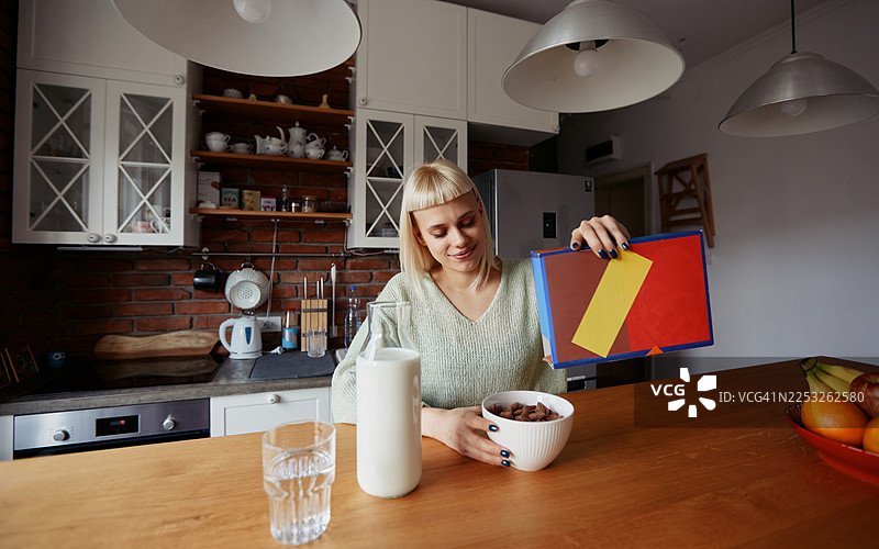 年轻时尚女性在家中享用早餐麦片和新鲜水果的晨间例行活动图片素材