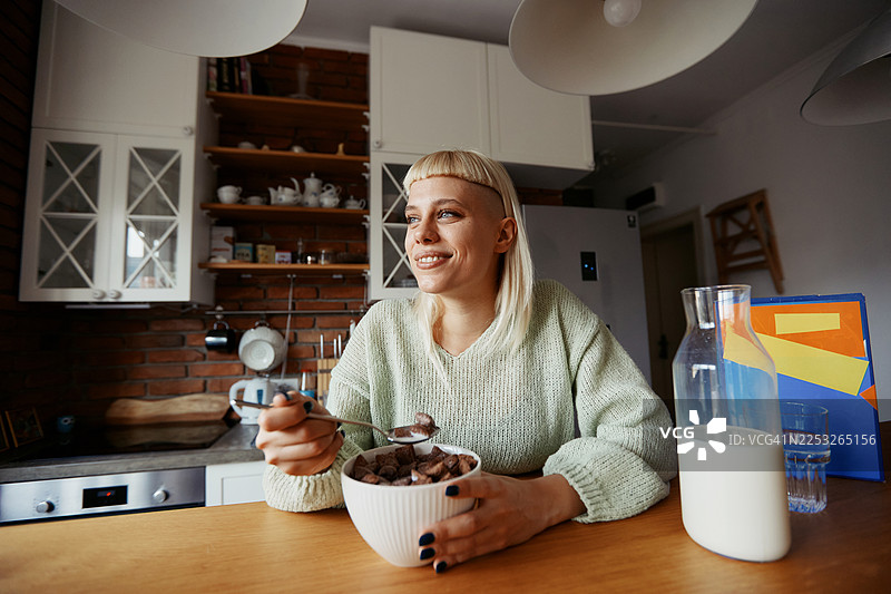 年轻的时尚女性在家办公期间，在现代厨房享用早餐，生活休闲图片素材