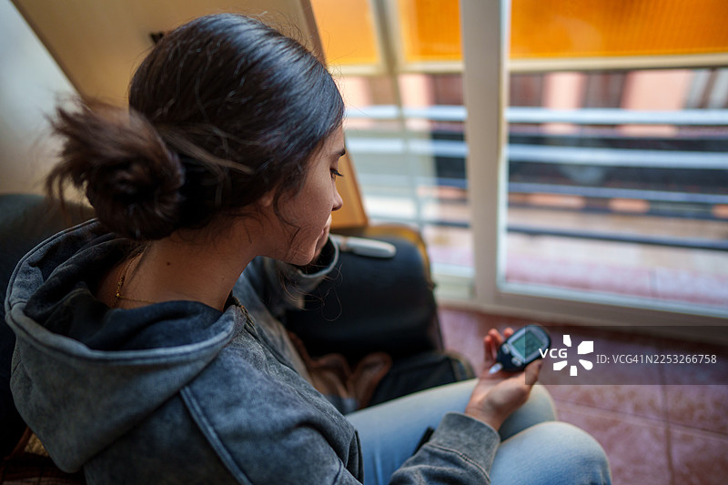 青少年在家中测量血糖水平图片素材