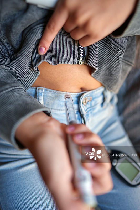 一个人用胰岛素笔向腹部注射胰岛素图片素材