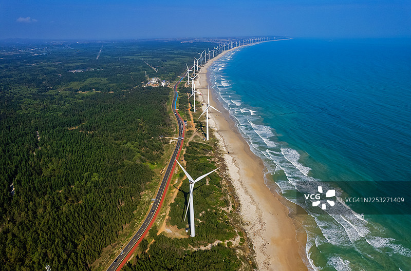 俯瞰海南海口市海滩海岸线上排列的风力涡轮机图片素材