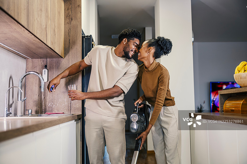 年轻的黑人夫妇在家中分担家务并互相表达爱意图片素材