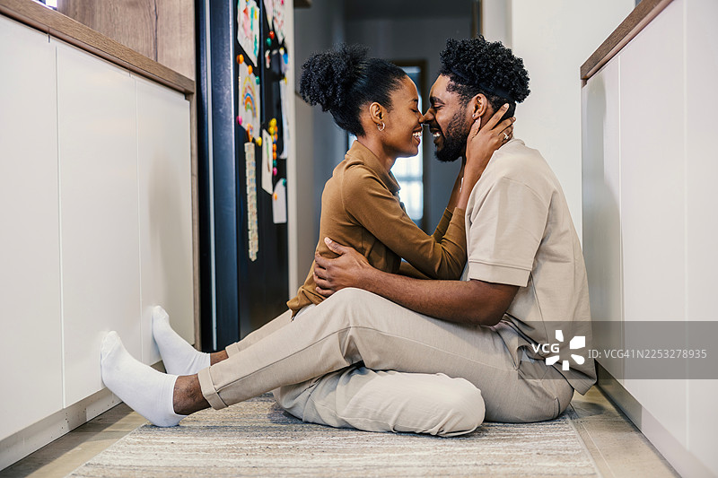 一对快乐的黑人夫妇在家中厨房拥抱图片素材