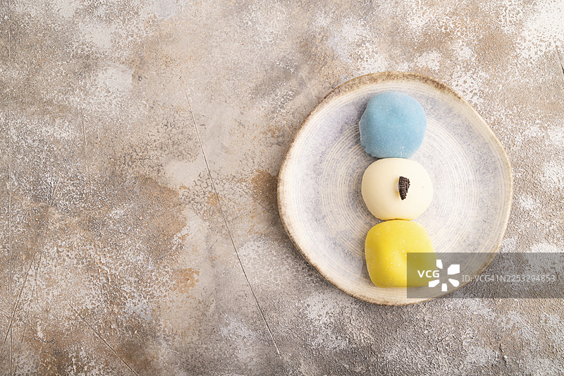 日式麻糬蛋糕，俯视，平铺，背景为棕色混凝土，留有复制空间图片素材