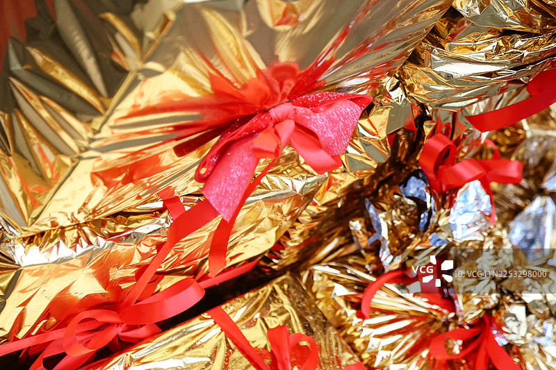 节日背景。全框金色礼品盒，配有红色蝴蝶结和丝带图片素材