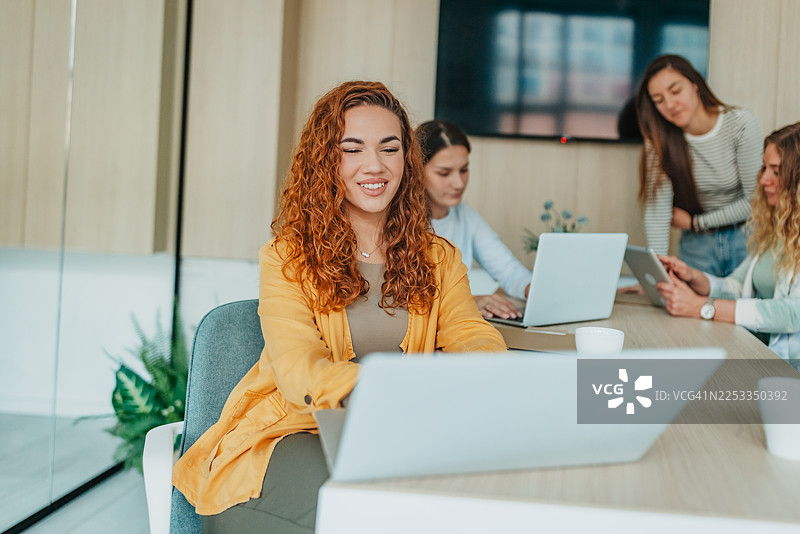 一群同事在现代办公室环境中，工作时间内利用科技处理办公事务图片素材