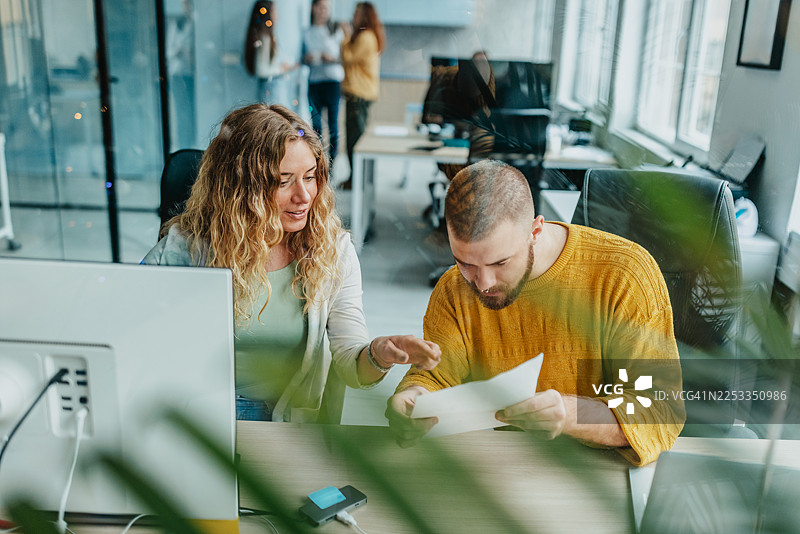 一群同事在工作时间内，在一个现代化的办公空间里一起合作项目图片素材