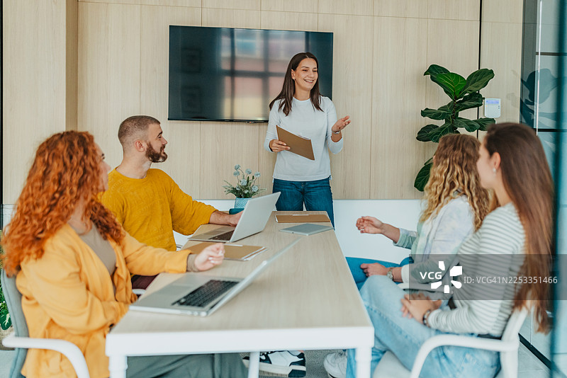 一群专业人士在现代办公室空间开会，同事之间进行协作活动图片素材