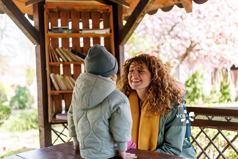 母亲和可爱的女儿在城市花园的阳光明媚的日子里享受亲子时光，玩得很开心图片素材