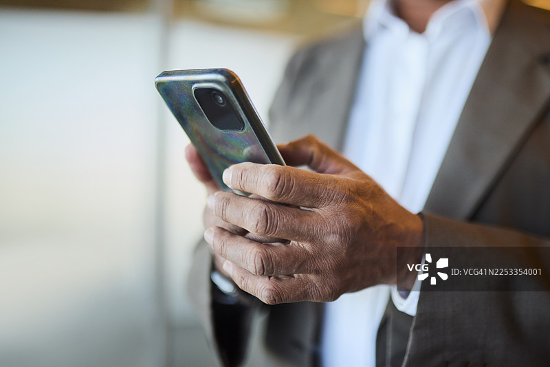 特写：商务人士在办公室用智能手机图片素材