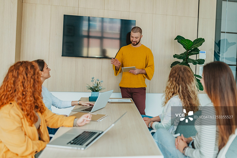 白天，人们在办公室环境中，利用科技进行会议，同事们互相协作。图片素材