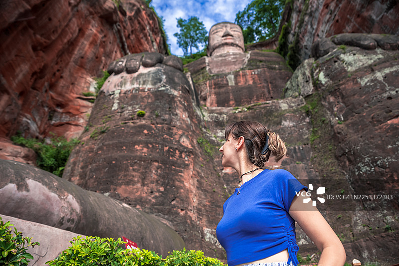 年轻女子惊叹于乐山大佛的宏伟图片素材