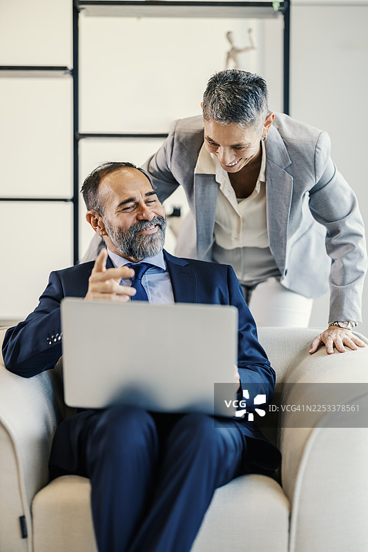 办公室里，商业同事们正在笔记本电脑上协作图片素材