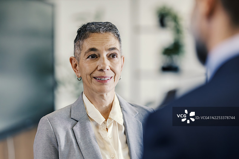 经验丰富的女商人指导年轻男同事图片素材