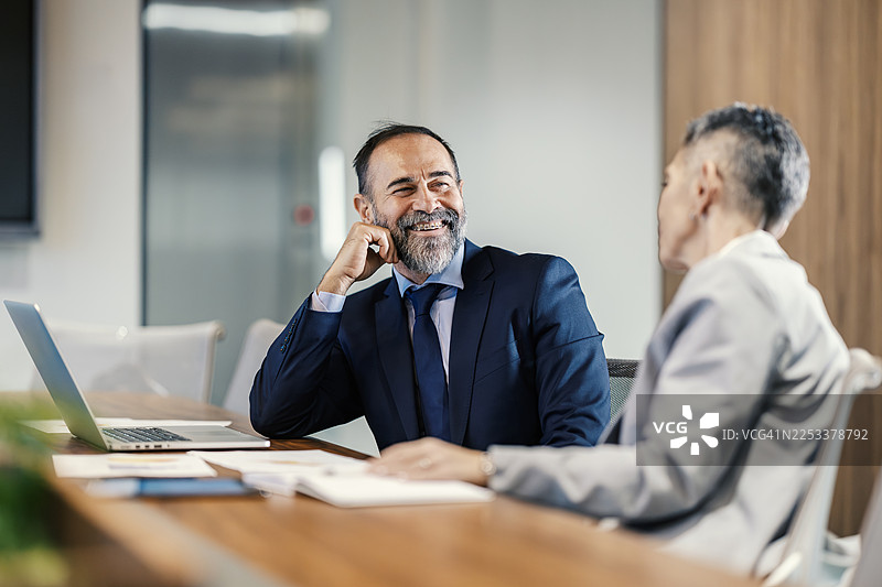 成熟的商务人士在公司会议上微笑图片素材