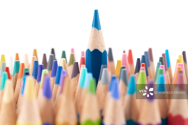 白色背景上堆叠的彩色铅笔，其中一支是独特的深蓝色铅笔。图片素材