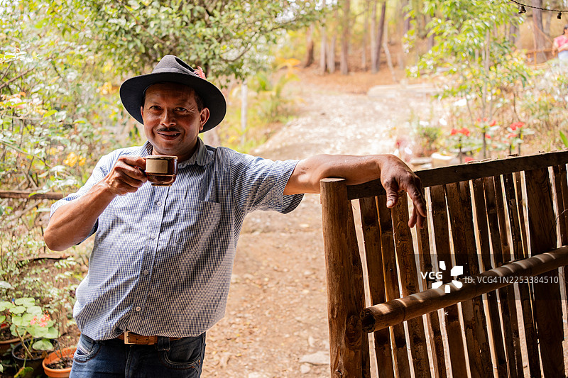 一位年长的农民在农场喝咖啡的肖像图片素材