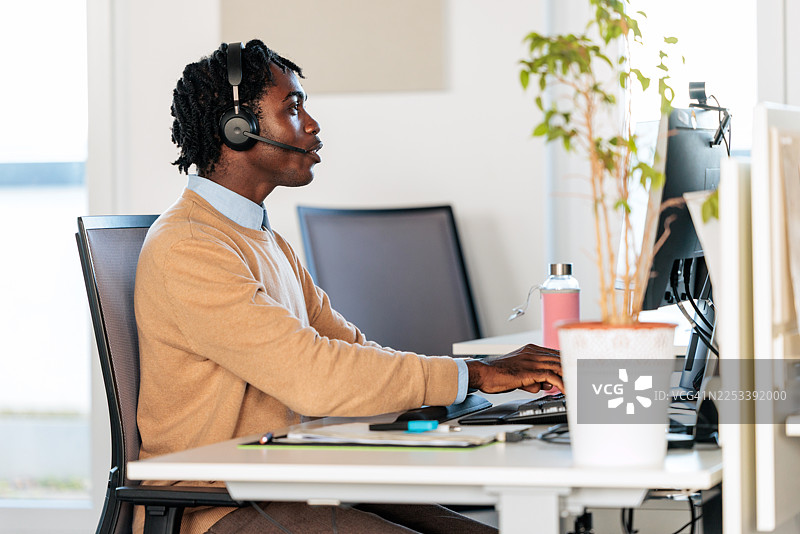 客服专员在办公桌前工作图片素材