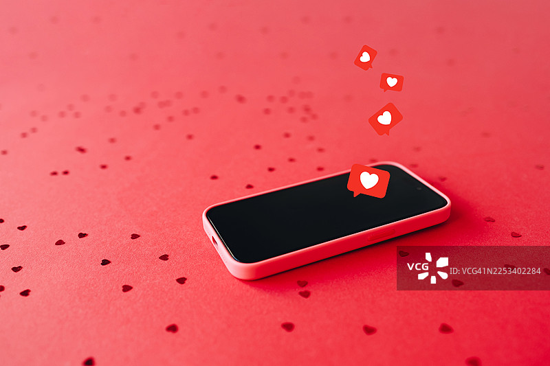 红底手机，配有心形纸屑和点赞图标，寓意数字浪漫与社交媒体互动概念。图片素材