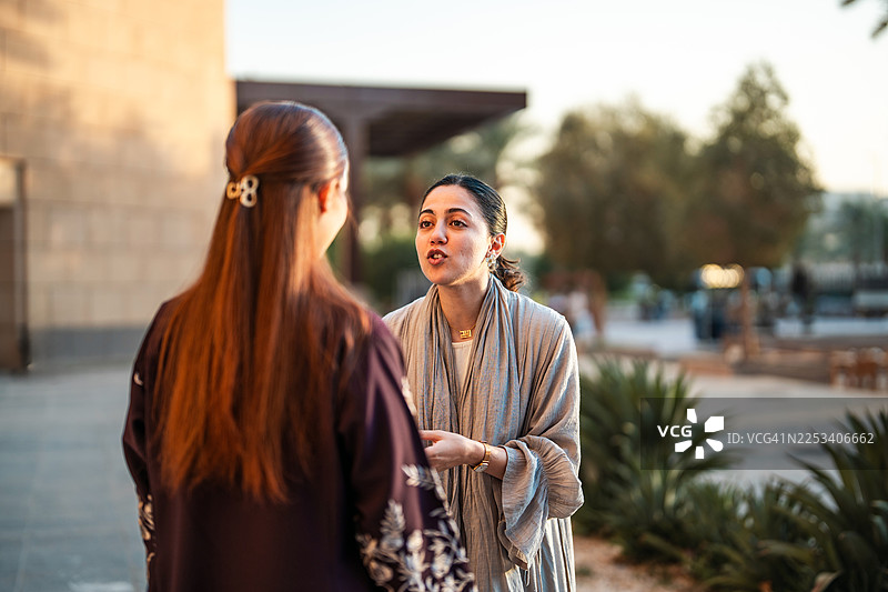 阿拉伯女性大学生在校园内愉快地交谈图片素材