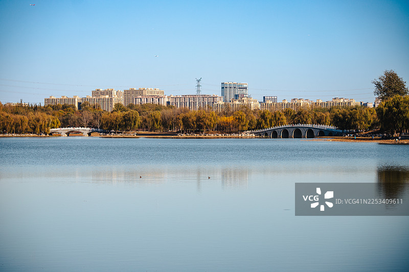 中国丰台，蓝天下的现代城市天际线与宁静流淌的河流构成了一幅风景画图片素材