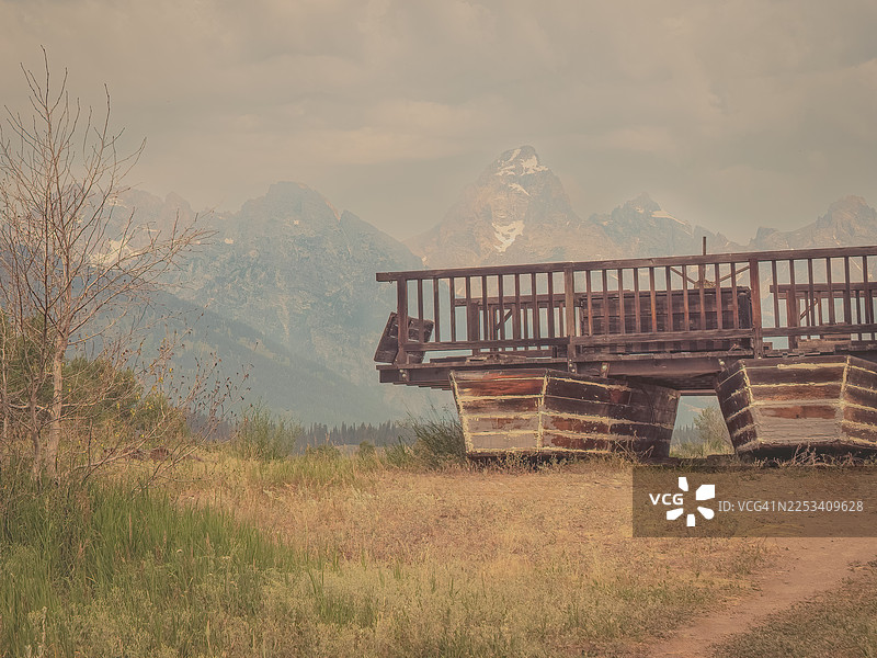 美国杰克逊大提顿国家公园，背景为山脉和干草的乡村木质建筑图片素材