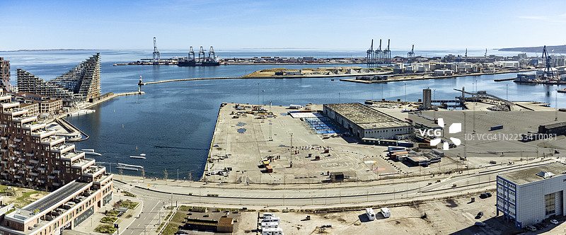 高角度全景，展现现代化城市港口，配有工业起重机和当代建筑，天空湛蓝晴朗图片素材