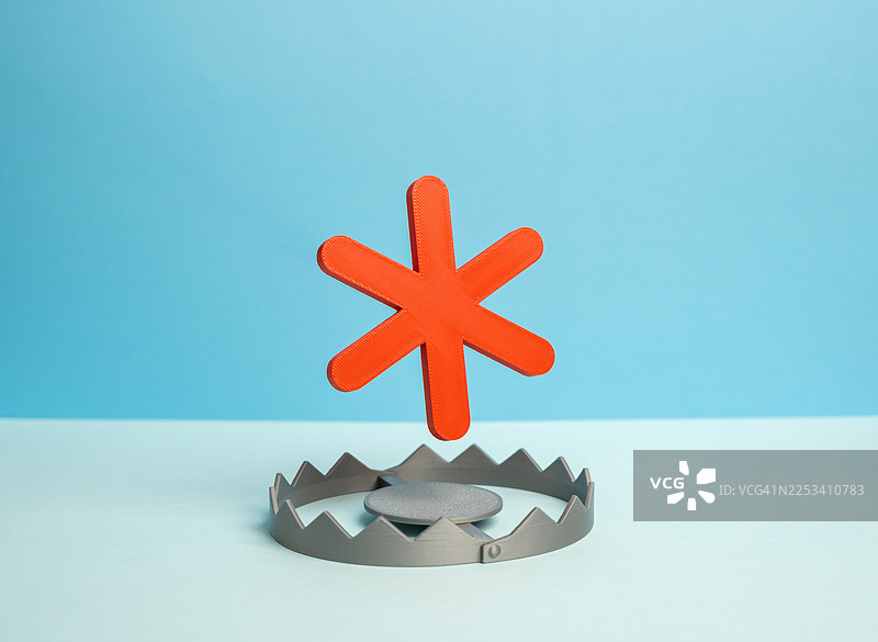 一个橙色的星号符号危险地悬停在一个捕熊夹上方，象征着隐藏的风险和细则图片素材