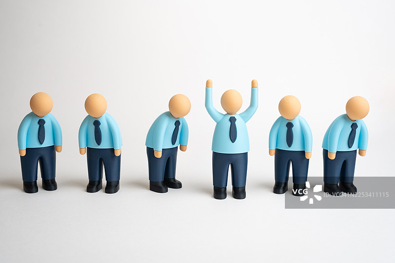一排微缩人物，其中一个庆祝成功，而其他的则情绪低落，象征着不同的商业结果图片素材