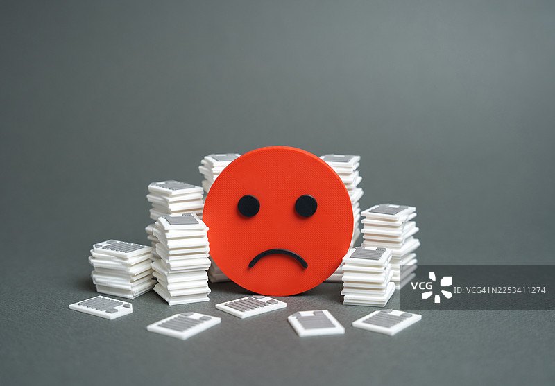 一个红色的悲伤表情符号，周围环绕着白色和灰色的方形积木堆，象征着失望或问题图片素材
