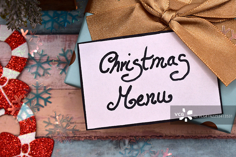 俯视视角下的圣诞礼物，配有圣诞菜单卡，周围环绕着节日装饰图片素材
