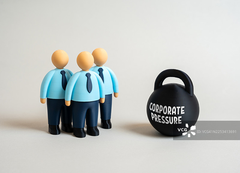 三个商业人士玩偶面对着标有‘企业压力’的壶铃，背景为白色图片素材
