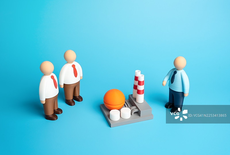 蓝色背景下，商务人士玩偶正在讨论一个工业项目，旁边有一个工厂模型图片素材