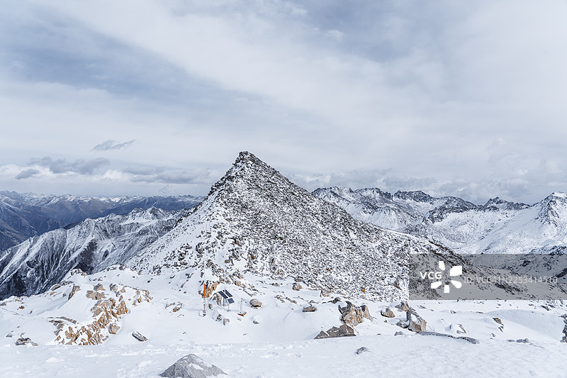 晴朗蓝天下白雪皑皑的雄伟山峰，远处是连绵的山脉，巴基斯坦图片素材