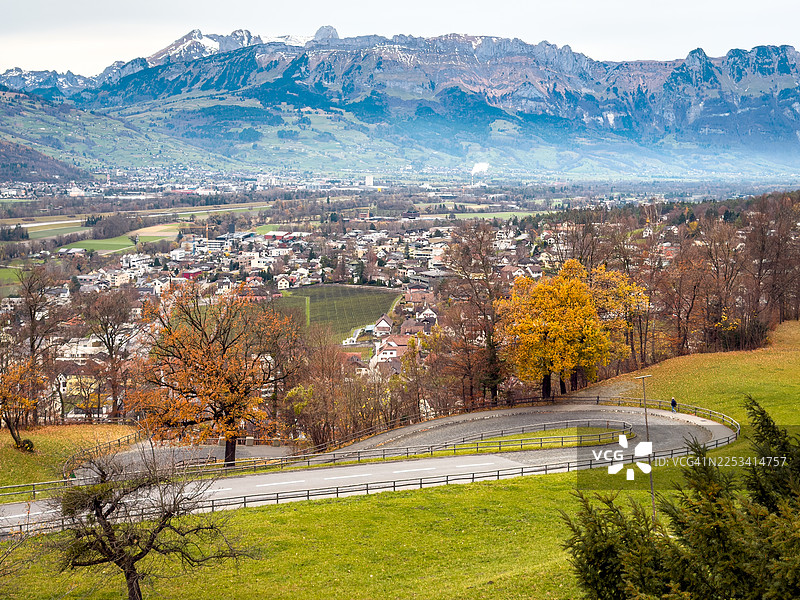 秋日美景，蜿蜒小路通往坐落在雪山旁的村庄图片素材