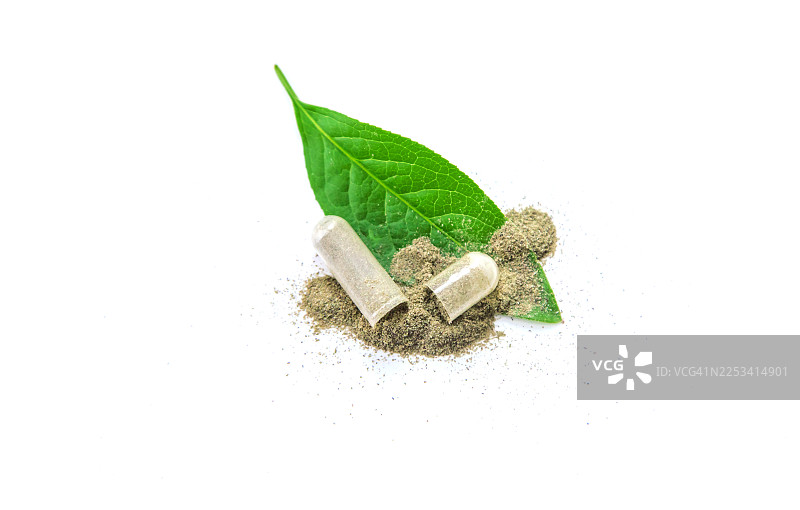白色背景上的草药胶囊，配有绿叶和粉末图片素材