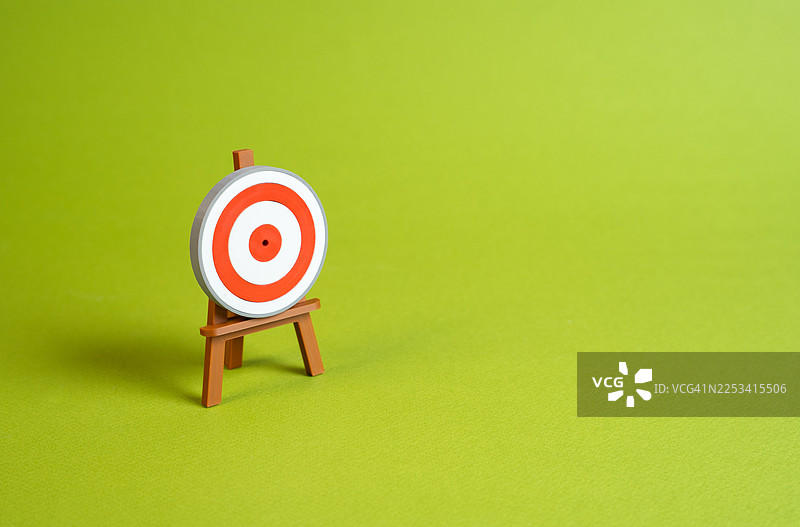 微型靶子立在画架上，背景是鲜艳的绿色，象征着目标和精准图片素材