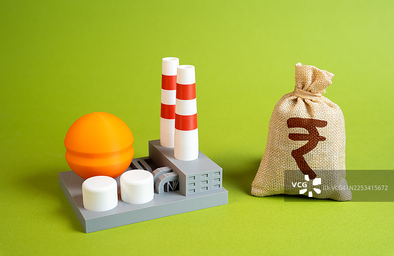 旁边放有卢比符号的钱袋的微型工厂模型，代表着工业投资和经济增长图片素材