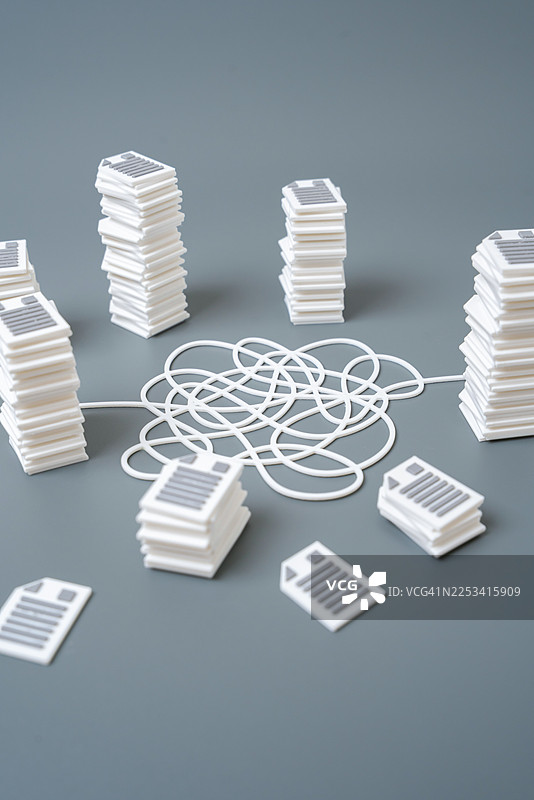 灰色背景下，交错的电线连接着文件堆，象征复杂的数据管理图片素材