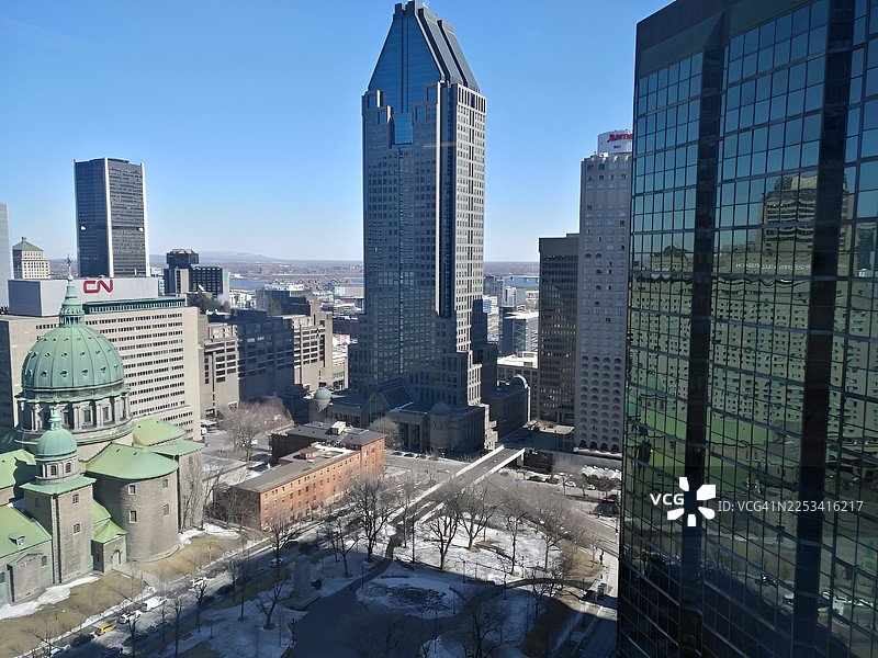 蒙特利尔城市天际线鸟瞰图，有现代摩天大楼和历史建筑，天空湛蓝，加拿大图片素材