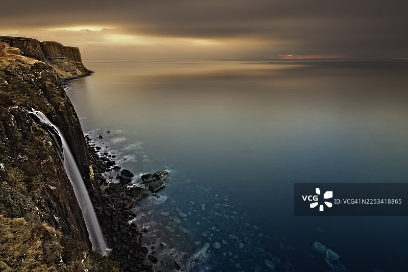 巴基斯坦，日落时分戏剧性的海岸风光，瀑布倾泻入海图片素材