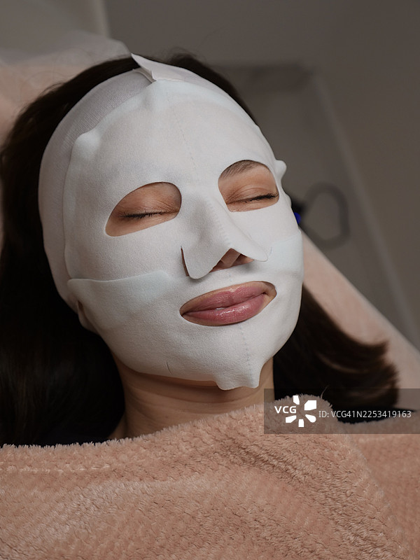 特写镜头：一位女士在家中放松，敷着面膜，专注于护肤和自我护理图片素材