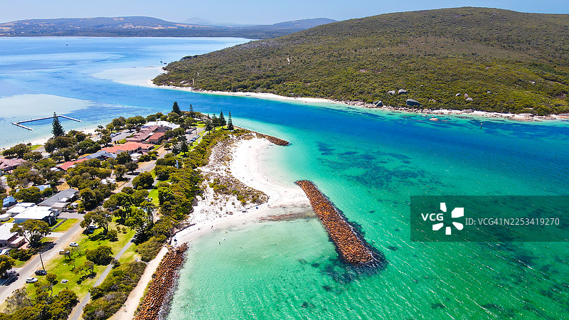 碧绿山丘和绿松石色海水环绕的海岸小镇的鸟瞰图，天空晴朗图片素材