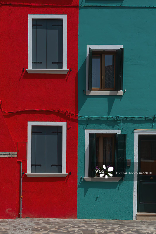 色彩鲜艳的红绿相间建筑外墙，带有窗户和百叶窗，意大利威尼斯，布拉诺朱德卡图片素材
