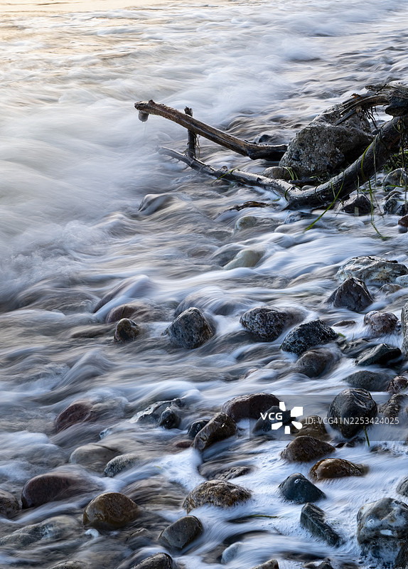 寒冷冬日，基尔，德国，希尔克塞，海浪拍打岩石和浮木的长曝光照片图片素材