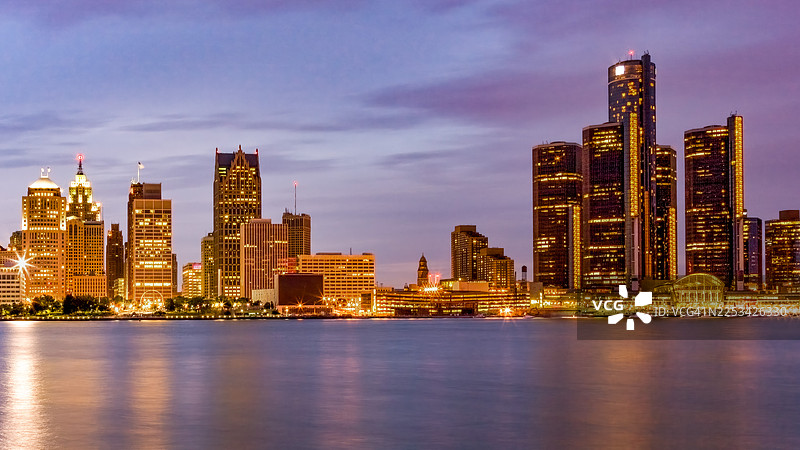 底特律天际线,黄昏时分,灯火辉煌的建筑倒映在底特律河中,展现了城市发展和充满活力的都市生活,底特律,美国,美国,底特律韦恩县港务局图片素材