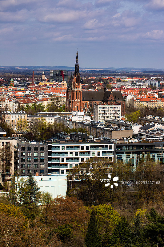 俯瞰城市，一座带有醒目教堂尖顶的建筑，新旧建筑交织，天空多云图片素材