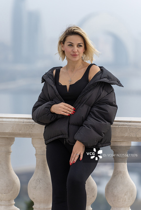 身穿黑色运动服和冬季外套的女性在户外微笑图片素材