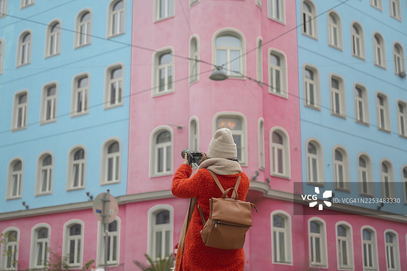 游客在维也纳，奥地利，在色彩缤纷的建筑背景下，手持相机探索城市图片素材