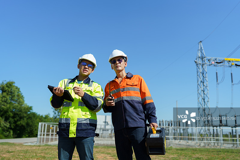 工程师正在检查大型风力涡轮机的运行情况，该涡轮机正在风力发电场发电。（照片）图片素材